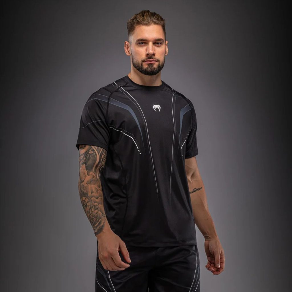 Мъж с черно-бяла тениска Venum Streamline Dry-Tech по време на тренировка – изглед отпред