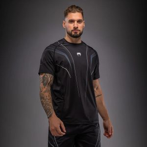 Мъж с черно-бяла тениска Venum Streamline Dry-Tech по време на тренировка – изглед отпред