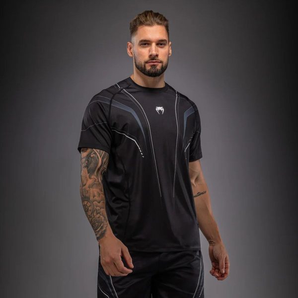 Мъж с черно-бяла тениска Venum Streamline Dry-Tech по време на тренировка – изглед отпред